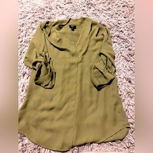 Green women’s blouse with button detail on sleeve